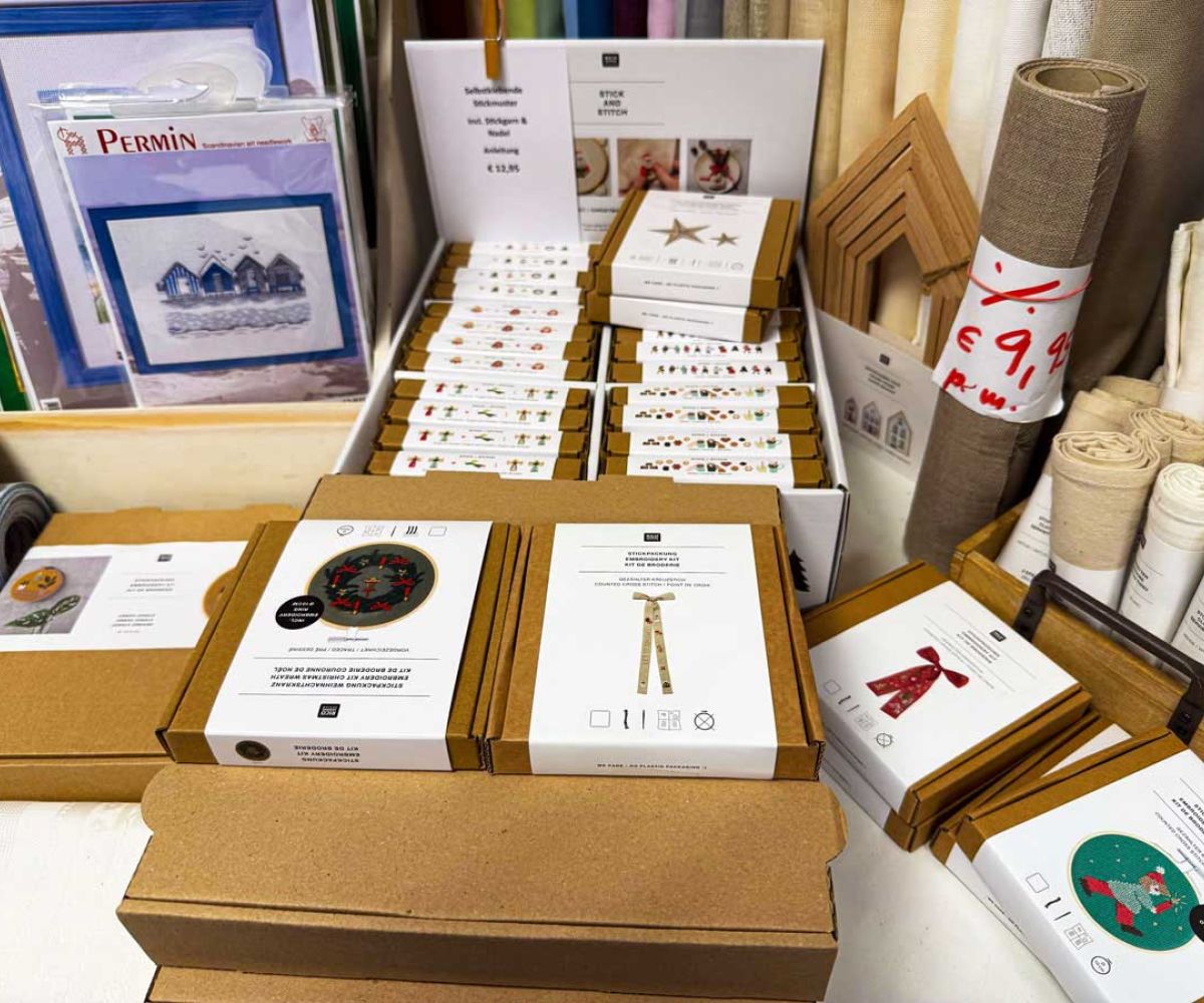auf dem Tisch liegend diverse Stickpackungen und Stickvorlagen mit unterschiedlichen Motiven